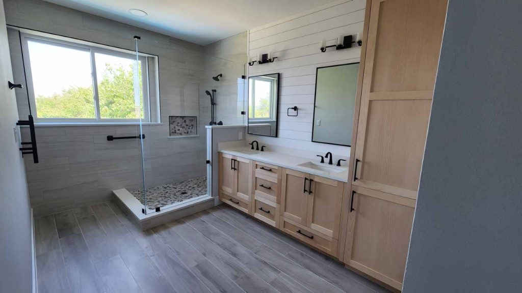 Bathroom remodel featuring clear maple vanity cabinets, a walk-in shower, and a shiplap feature wall in the Point Venture area of Lago Vista, Texas.