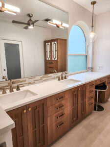 Austin bathroom remodel featuring mixed materials: vanity cabinet, countertop, mirror with mounted lights, and pendant lighting”