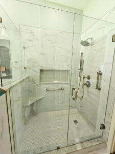 Shower with stainless steel faucets and hardware in Round Rock bathroom remodel
