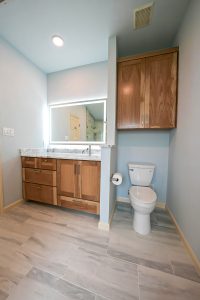 Round Rock bathroom with vanity cabinet and over-the-toilet storage cabinet for extra space