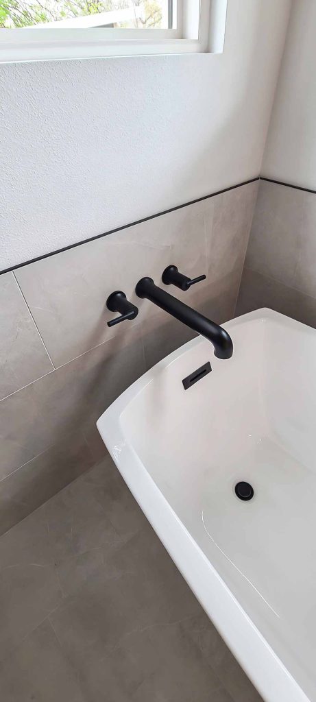 Modern Austin bathroom with a free-standing tub and matte black fixtures.