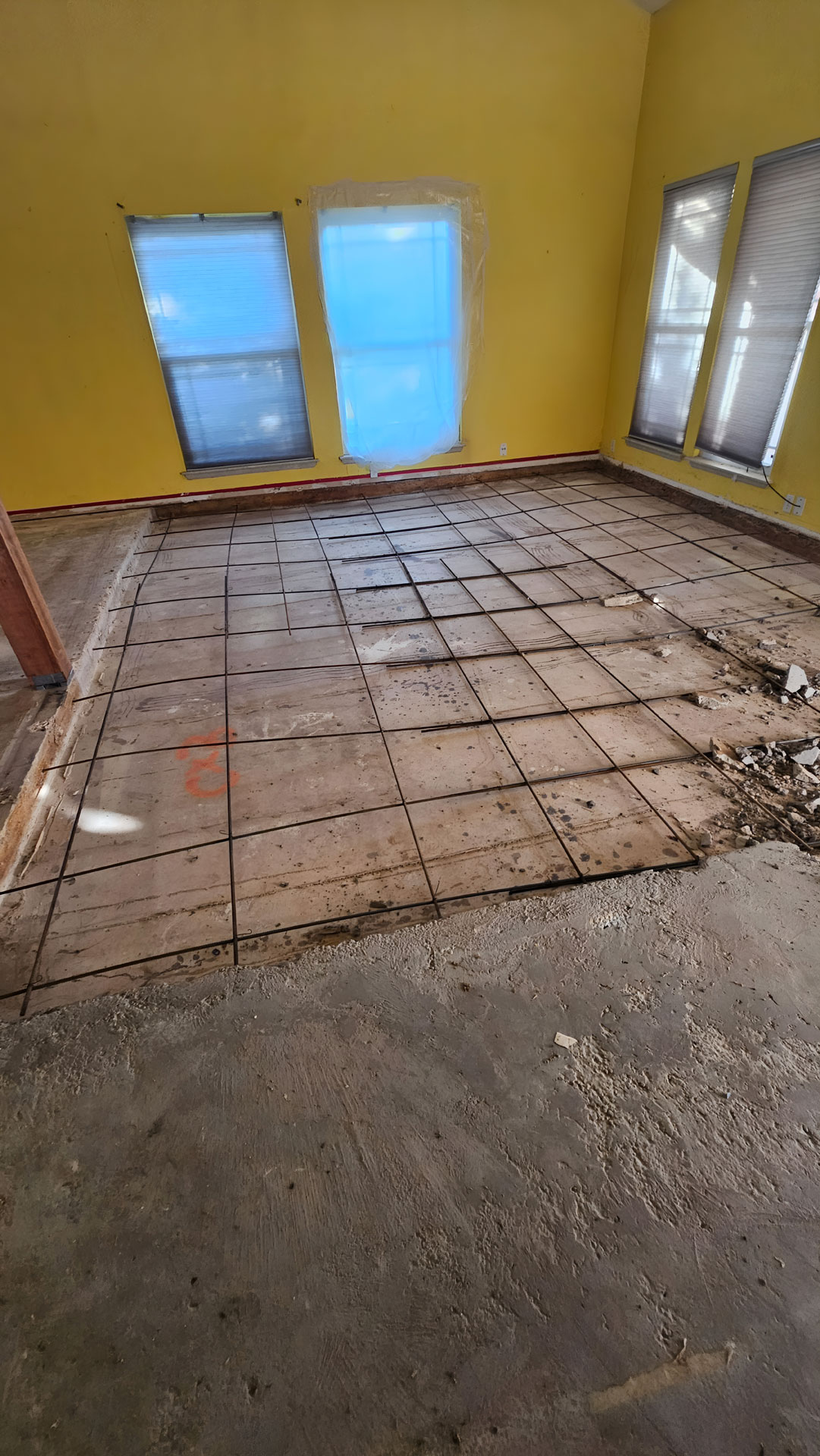 Sunken living room floor being filled with concrete to raise it to the level of the surrounding rooms.