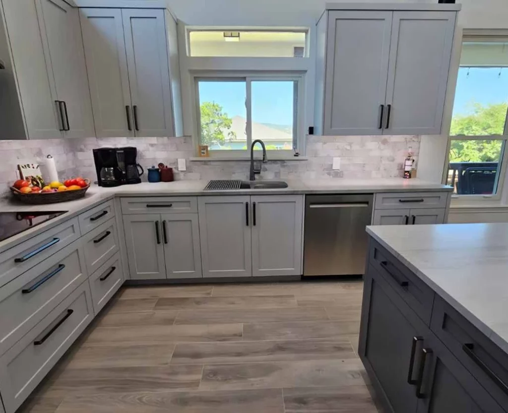 Newly remodeled kitchen with painted shaker-style cabinets and engineered-stone countertops in the Lago Vista area.